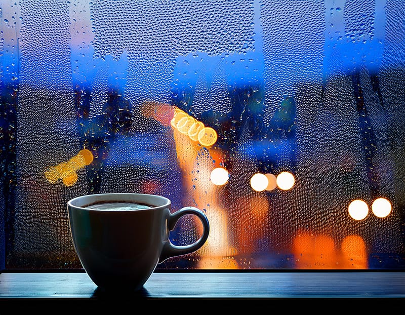 夕暮れ時、カフェの窓辺に置かれた、飲みかけのコーヒーカップ